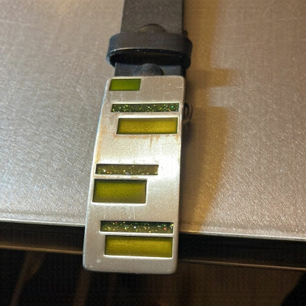 Black leather belt with silver and green buckle